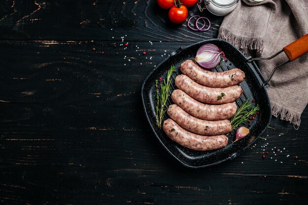 Raw stuffed sausages on srill pan with spices and rosemary on cutting board Cooking ingredients Natural healthy food concept top view