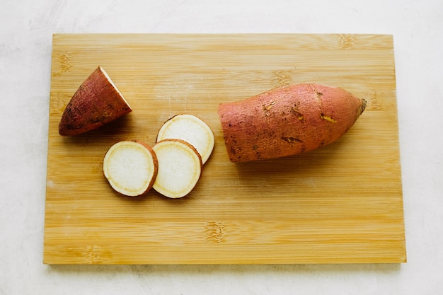 Photo raw sweet potato tuber and slices on chopping board cooking homemade simple food yam