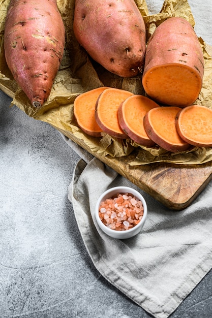 Raw sweet potatoes on a chopping Board, organic yam. 