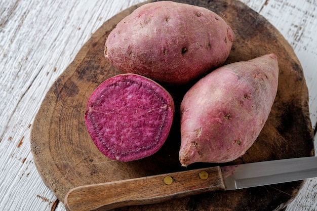 Raw sweet potatoes on wood background with filter effect retro vintage style