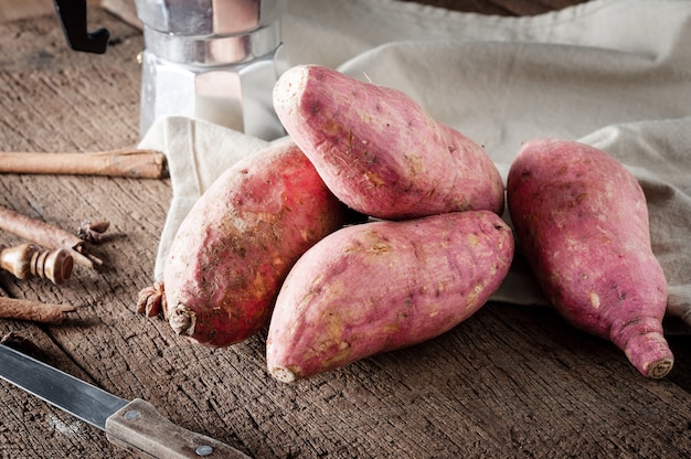 Raw sweet potatoes on a wooden table