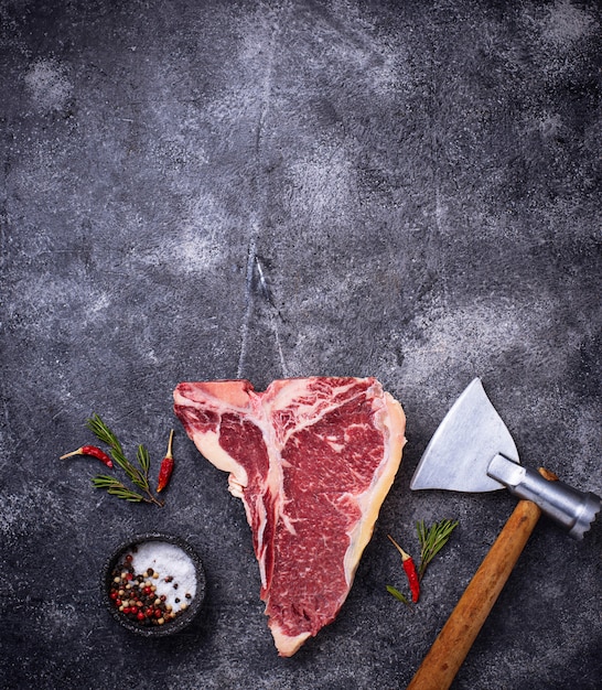 Raw T-bone steak with hatchet