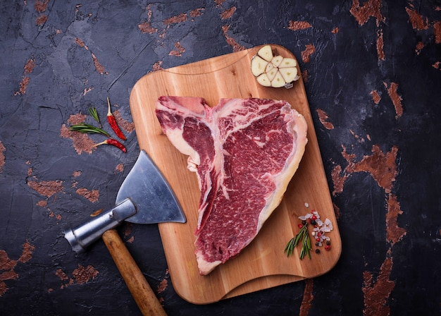 Raw T-bone steak with hatchet