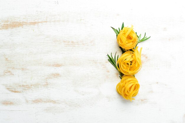 Raw tagliatelle pasta and ingredients. Food background.