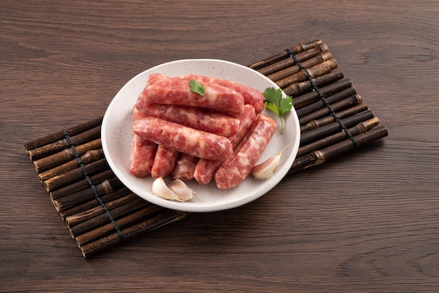 Raw Taiwanese sausage in garlic flavor in a plate on wooden table background
