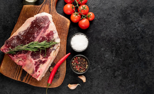 Raw tbone steak with spices on a stone background dryaged steak with copy space for your text