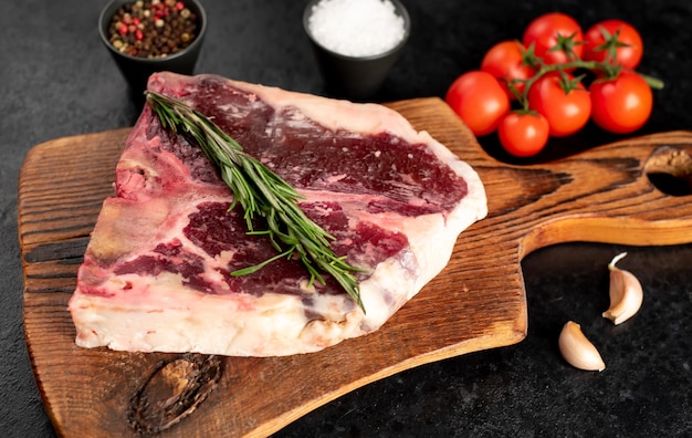 Raw tbone steak with spices on a stone background dryaged steak