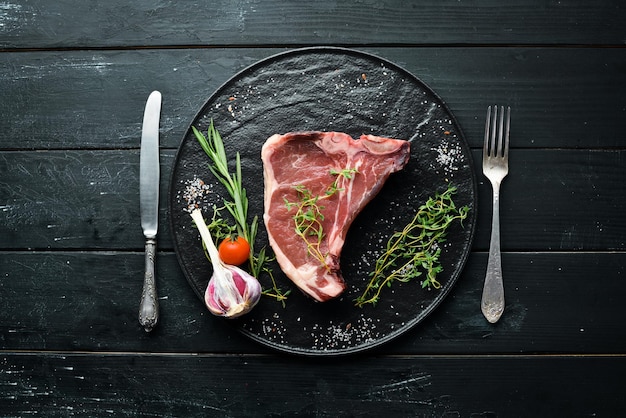 Raw Tbone steak on a wooden table Top view Free space for text