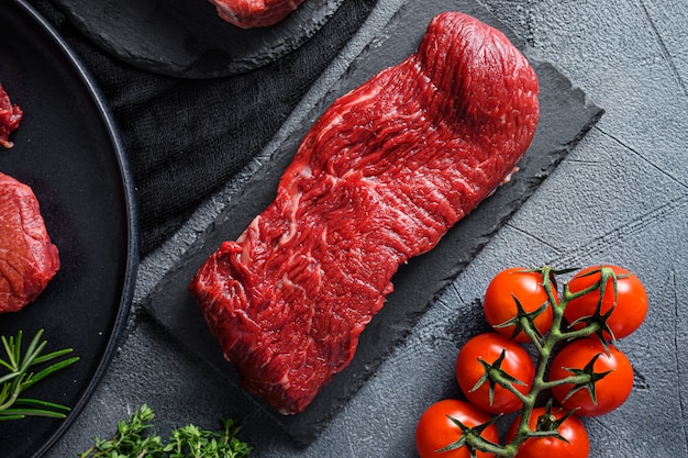 Raw top blade steak on a black stone