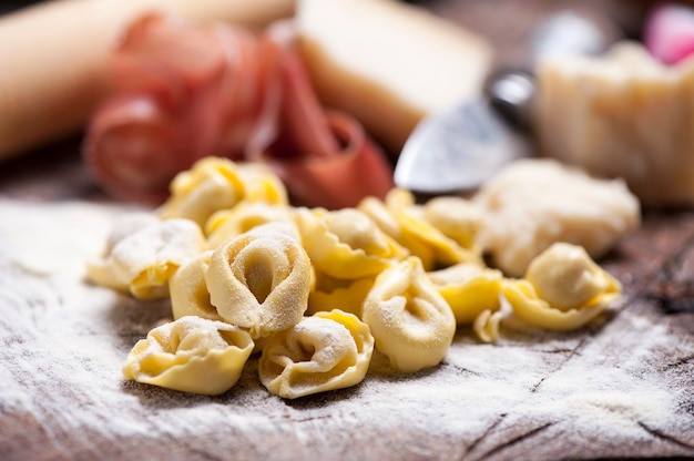 Raw tortellini on rustic  wooden table