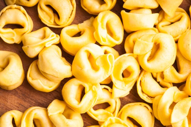 Tortellini crudi sulla tavola di legno, preparati per la cottura