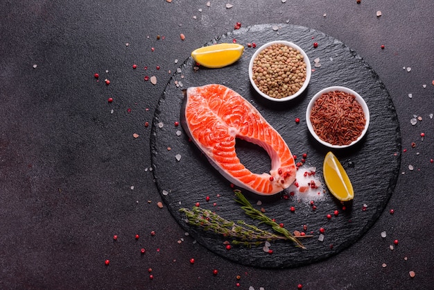 생 송어 붉은 생선 스테이크 허브와 레몬, 올리브 오일과 함께 제공됩니다. 연어 요리. 건강한 식생활 개념