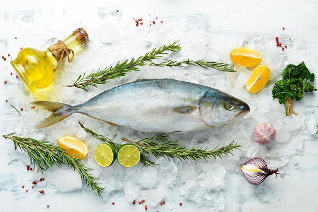 スパイスとハーブを使った生のマグロ魚料理白いキッチンの背景にシーフードを調理する上面図