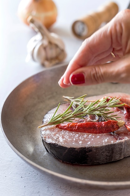 Foto bistecca di tonno crudo sul piatto e tavolo in legno