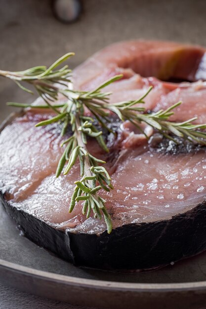 Raw tuna steak on plate and wooden table