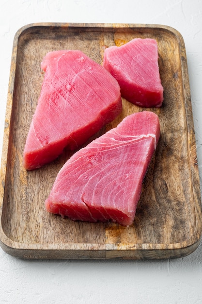 Raw tuna steak set, on wooden tray, on white stone 