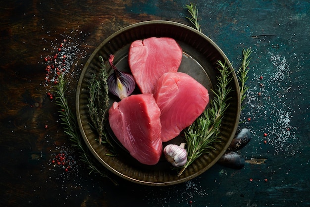 Raw tuna steak with rosemary On a dark background Flat lay