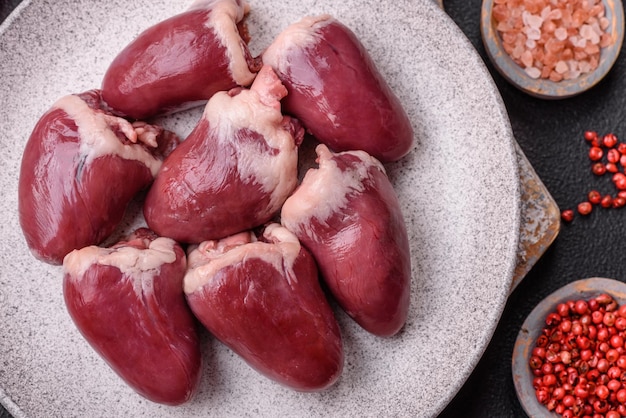 Photo raw turkey or chicken hearts with salt and spices