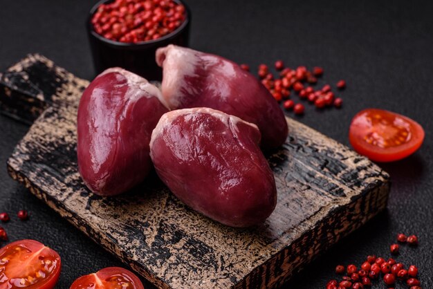 Photo raw turkey or chicken hearts with salt and spices