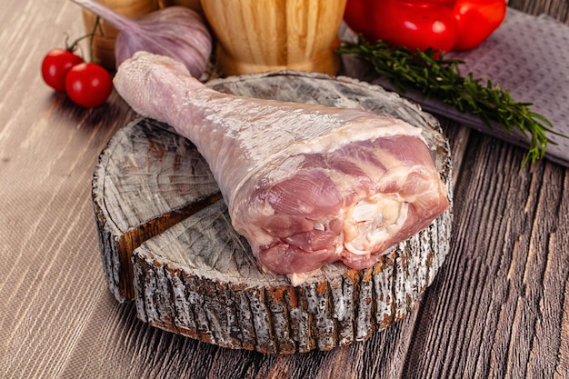 raw turkey drumstick leg over board