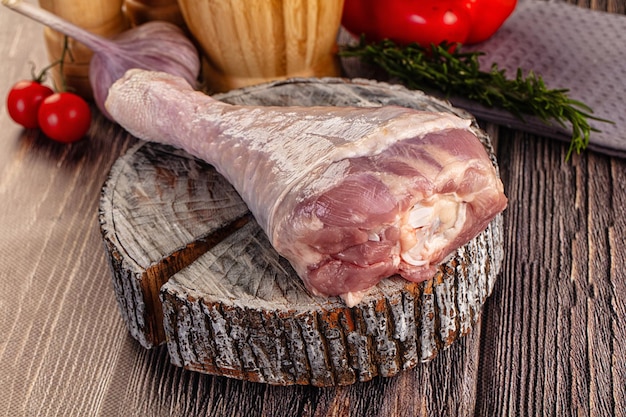 raw turkey drumstick leg over board