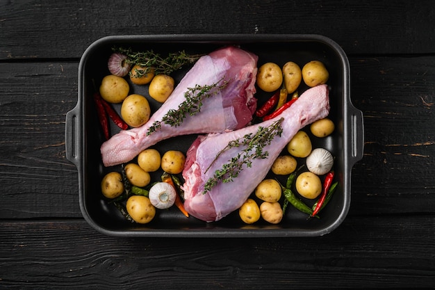 Raw turkey drumsticks with thyme pepper on black wooden table background top view flat lay with copy space for text