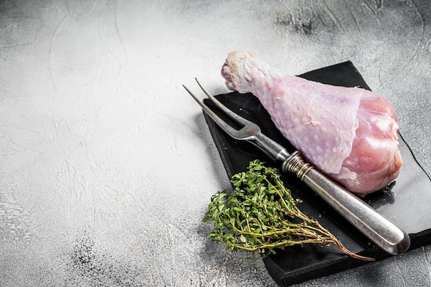 Raw turkey leg thigh with thyme and spices White background Top view Copy space