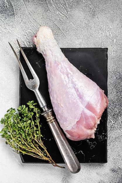 Raw turkey leg thigh with thyme and spices White background Top view