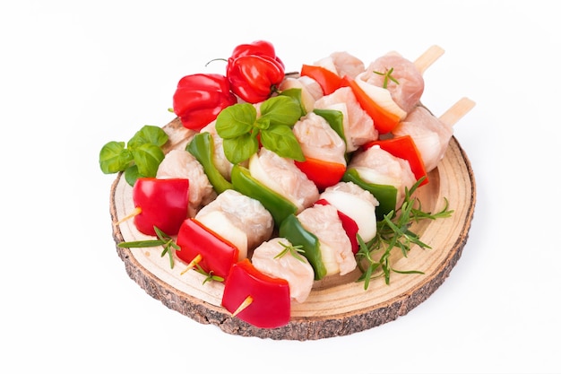 Raw turkey skewers with vegetablespeppersonions white backgroundskewers with pieces of raw meatred a