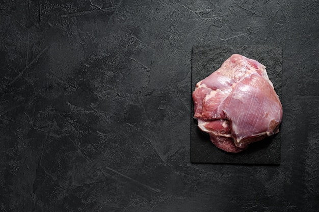 Raw Turkey thigh fillet. Farm eco meat. Dark background. Top view.