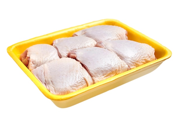 Raw and uncooked chicken thighs yellow plastic container Meat of poultry in tray isolated on white