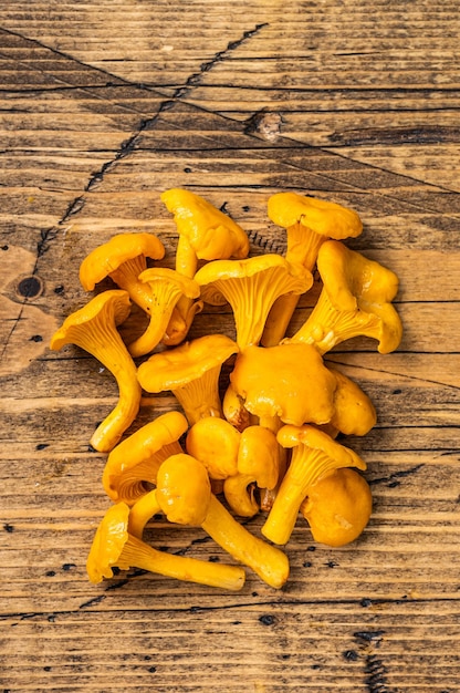 Raw uncooked wild Chanterelles mushrooms.  Wooden background. Top view.