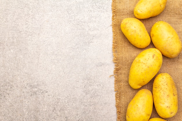 Raw unpeeled young potatoes on sackcloth