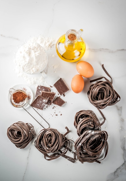 Raw unprepared chocolate pasta noodles, with ingredients for cooking