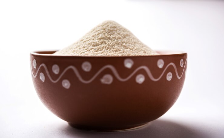फोटो raw unprepared semolina flour also known as rava powder in hindi in bowl or spoon. close-up isolated on white or moody background. selective focus