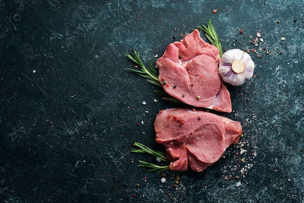 Raw veal meat Two raw steaks with spices Top view Free space for your text