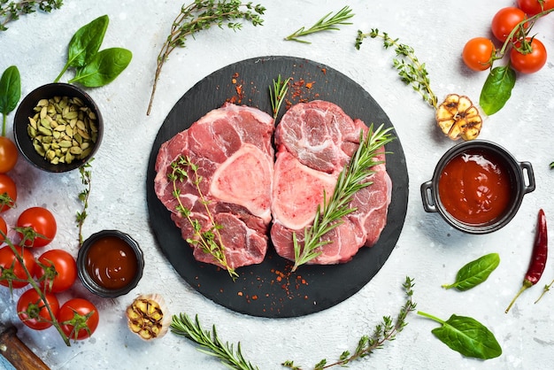 Bistecca di ossobuko di vitello crudo con osso carne su fondo di pietra