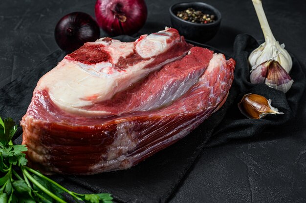 Raw veal shank on black background