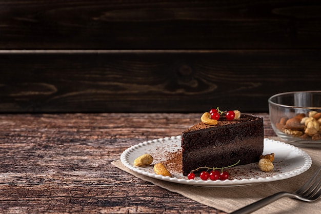 Raw vegan chocolate cashew cake on dark vintage background