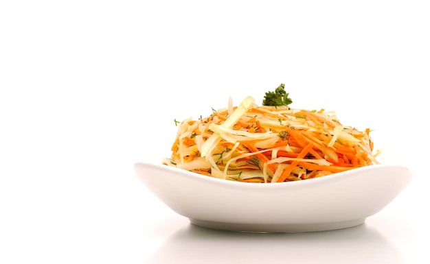 Raw vegetable salad with carrot and cabbage isolated on white