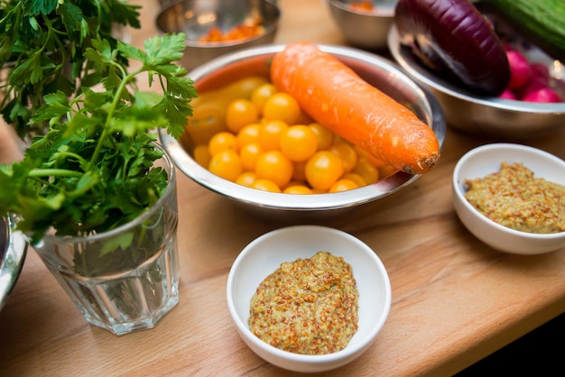 Raw vegetables on a table Ingredients for cooking carrot parsley cherry tomatoes Dijon mustard