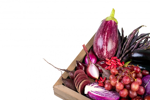 Raw violet vegetables and fruit on white background.