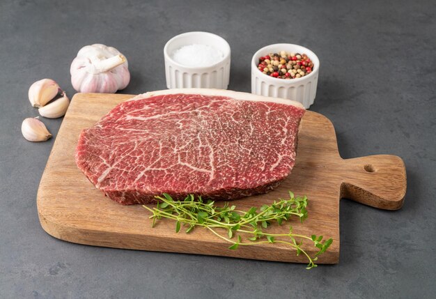 Carne cruda dell'arrosto della spalla di wagyu sopra la tavola di legno con i condimenti