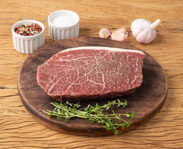 Raw wagyu shoulder roast meat over wooden board with seasonings