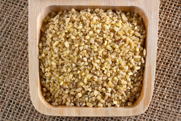 Raw wheat grains in wooden plate