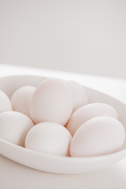 Raw white eggs on plate on table.