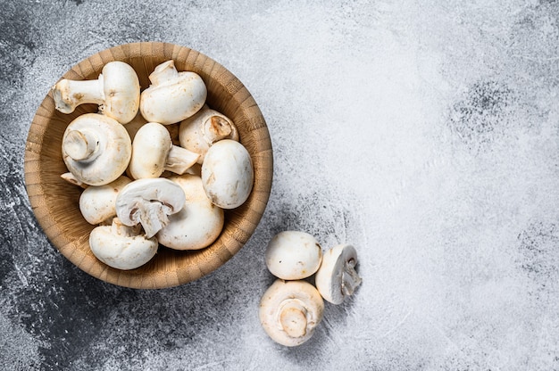 Raw white mushrooms in a bamboo bowl. 