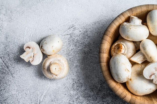 Raw white mushrooms in a bamboo bowl. 