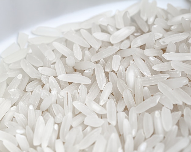 Raw white rice in a bowl in a close up photo with top view