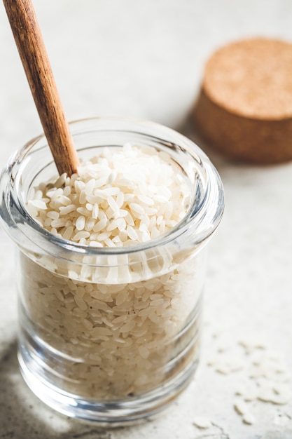 Raw white rice in glass jar. Cooking food concept.